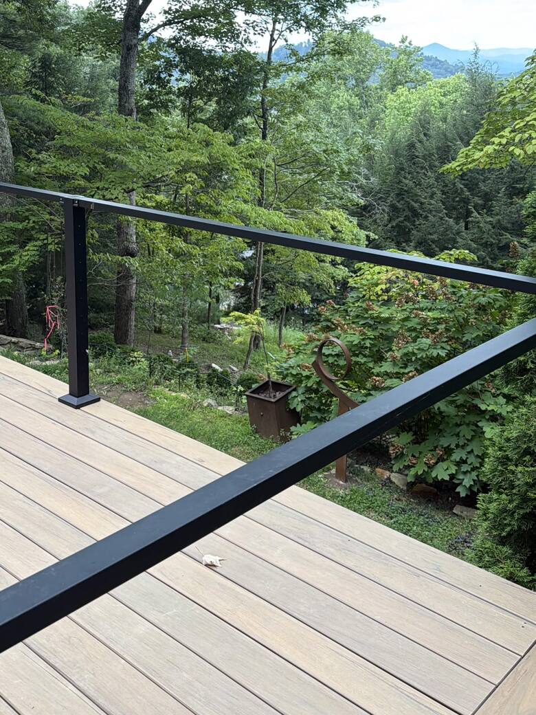 Finished composite deck boards framed by black railing with mountain ridges beyond