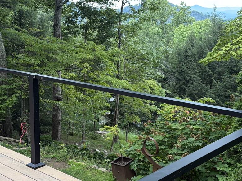Finished composite deck with black railing and a mountain view